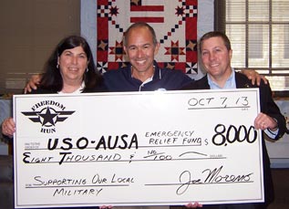 photo of a check being presented to USO and AUSA